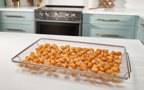 Air fried tater tots on counter by air fryer oven