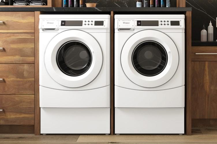 A Whirlpool® laundry pair in between cabinets.