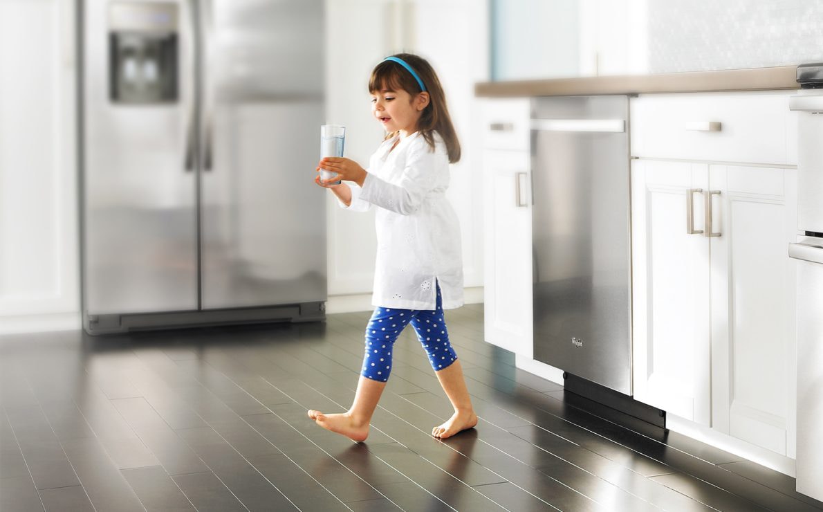 A girl carrying a glass of water.