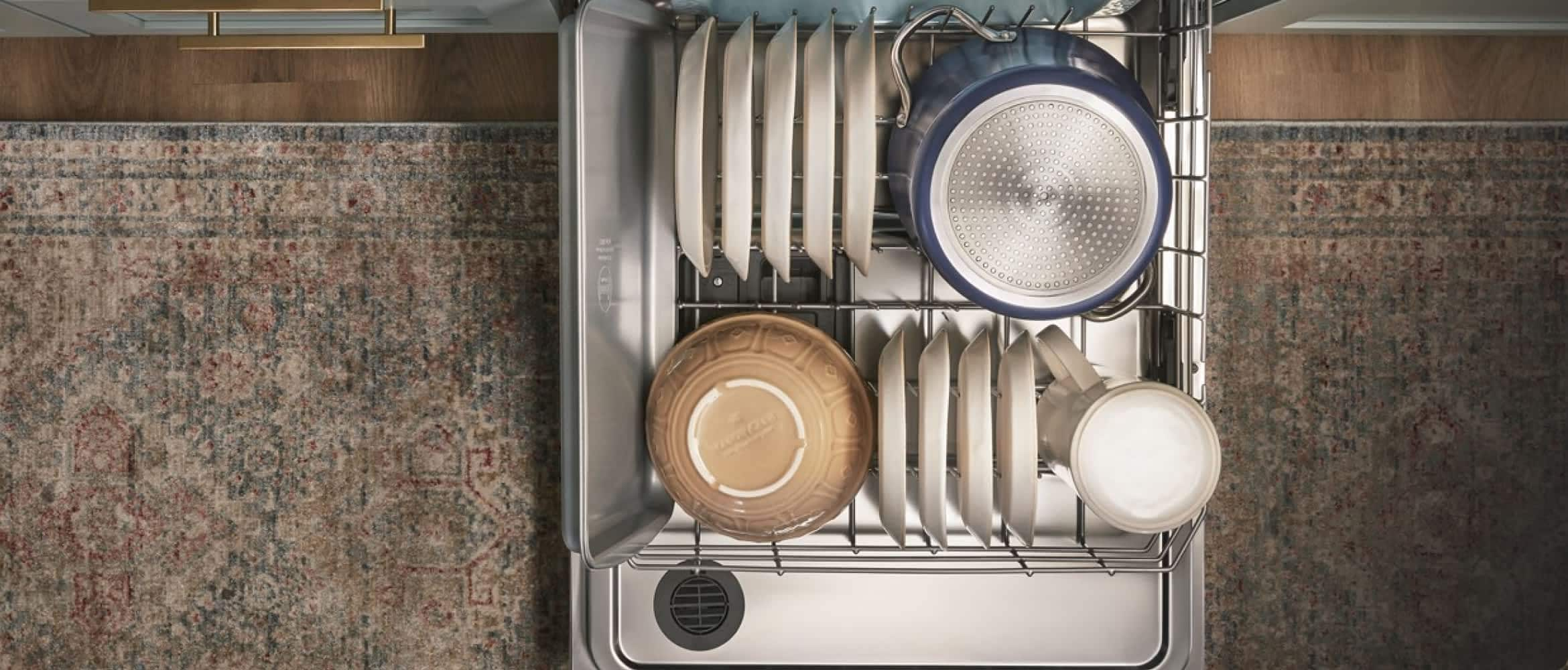 A top-down view of a fully loaded bottom rack of a dishwasher