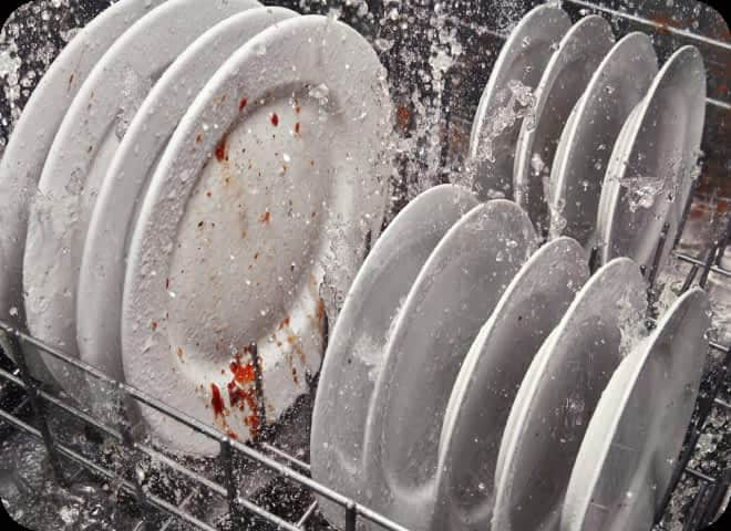 Water spraying dirty plates in a dishwasher