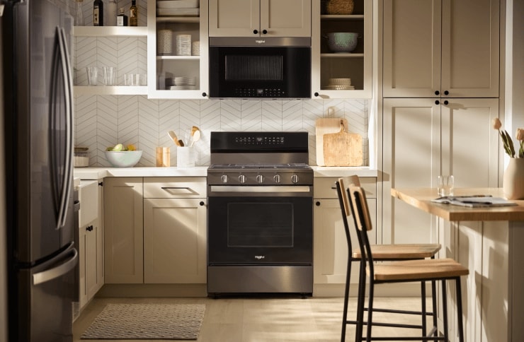 A Whirlpool® Freestanding Range and Over-the-Range Microwave in a kitchen with light taupe cabinets