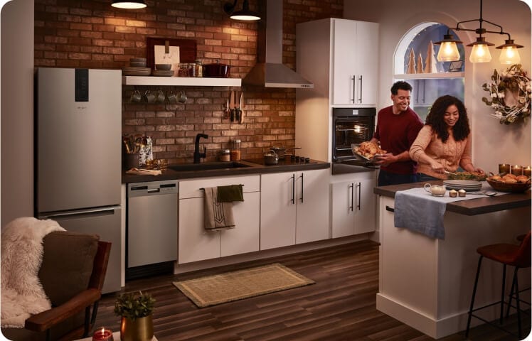 Two people preparing food in a small space kitchen