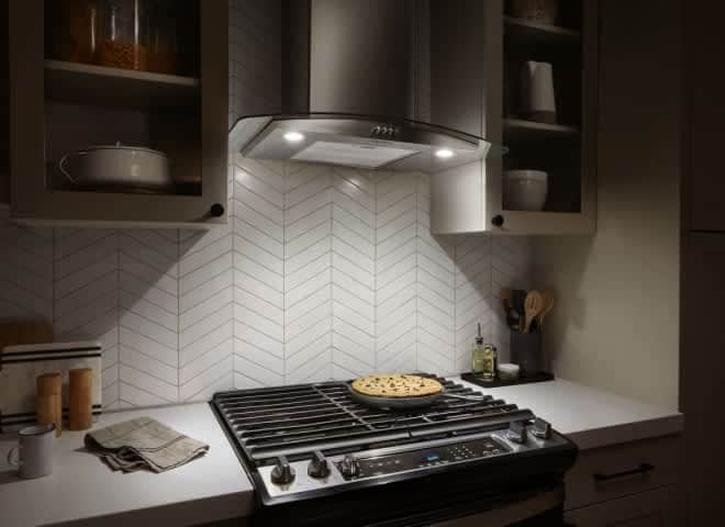 LED Task Lighting from a Whirlpool® Canopy Hood shines down on a cooktop