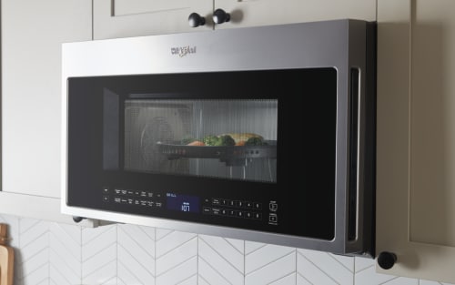 Over-the-range, Whirlpool® stainless steel microwave with chicken and vegetables inside