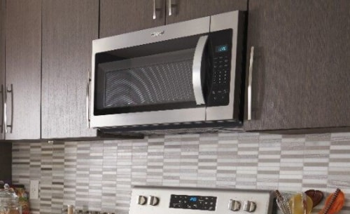 Over-the-range microwave installed and surrounded by brown cabinetry