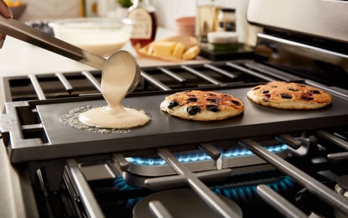 Pancakes cooking on a stovetop griddle