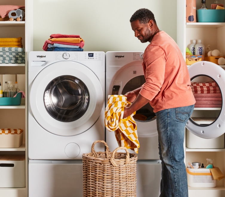 A person taking clothes out of a Whirlpool® Dryer