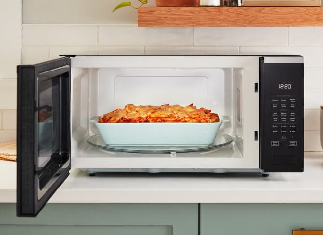 A casserole dish with baked ziti sits inside of a Whirlpool® Microwave