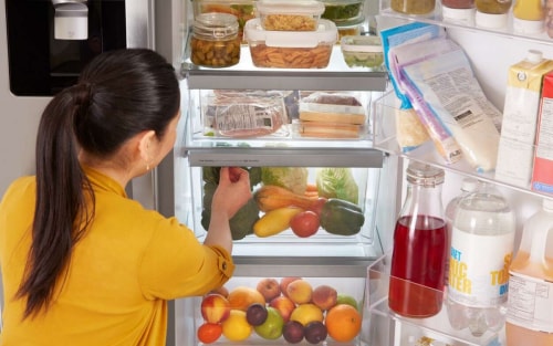 Person adjusting the humidity levels on a refrigerator crisper drawer