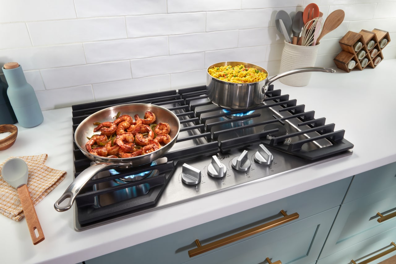 Pots and pans cooking on a gas cooktop.