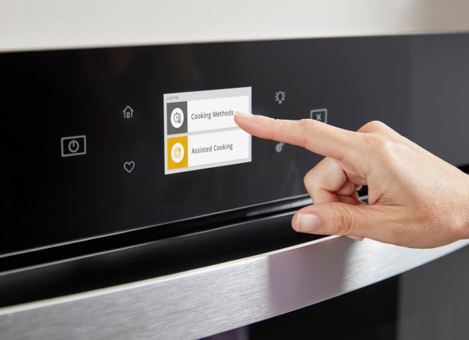 A hand selecting Cooking Methods on a wall oven Touchscreen