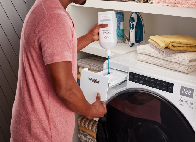 A person adding laundry detergent to the Load & Go™ XL Dispenser drawer.