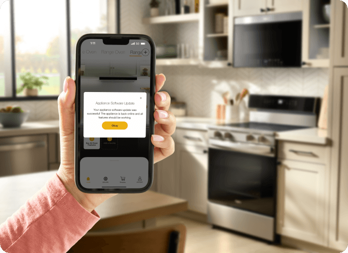 A hand holding the Whirlpool® App showing an update for the Whirlpool® Smart Range