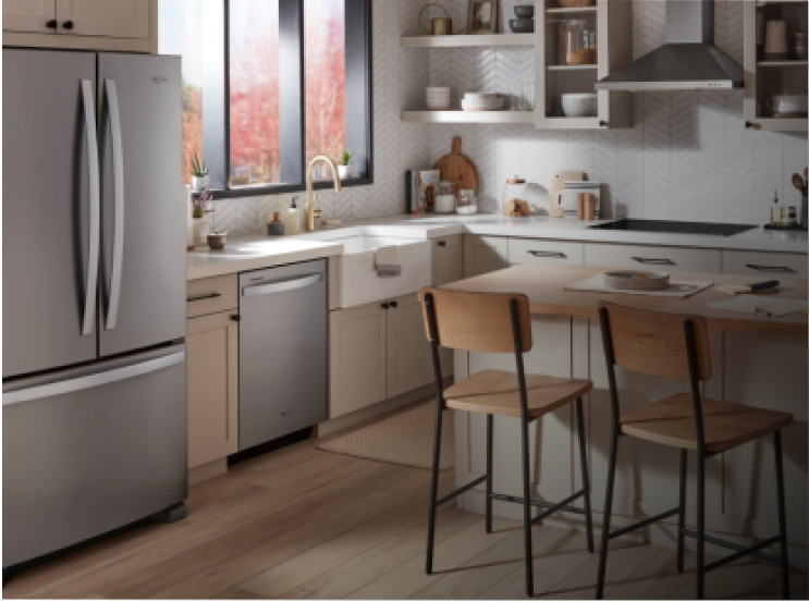 A kitchen with light cabinets and an island with two counter-height chairs