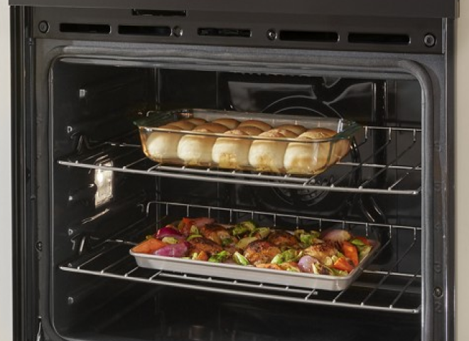 Rolls and a sheet pan dinner on different racks in a wall oven